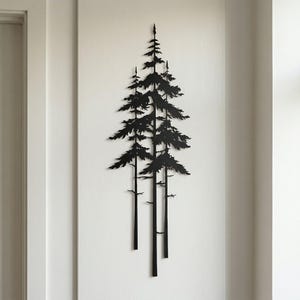 May include: Black metal wall art depicting a stylized forest scene with several tall pine trees. The trees have detailed branches and needles, creating a silhouette against the white wall. The artwork is mounted vertically.