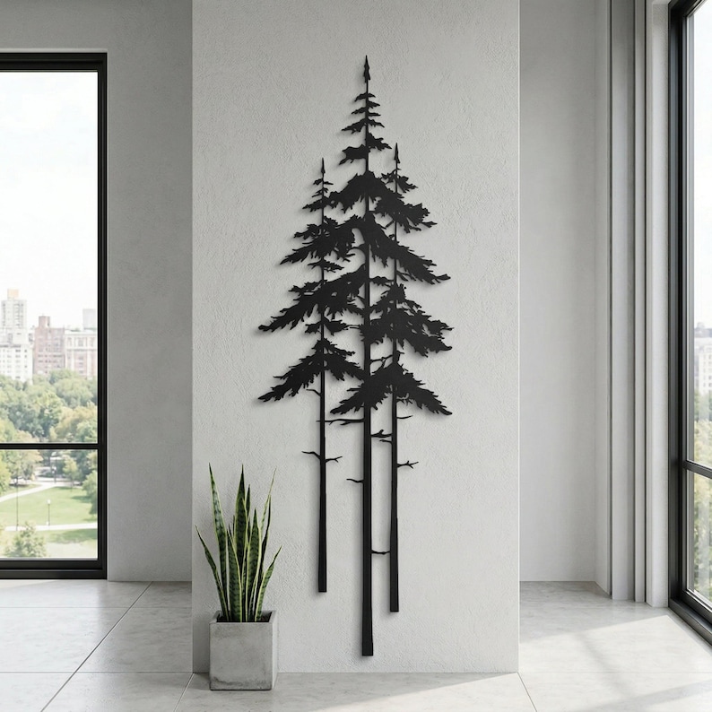 May include: Black metal wall art depicting a stylized forest scene with three tall pine trees. The artwork is mounted on a white wall in a modern interior setting, with a potted plant in the foreground.