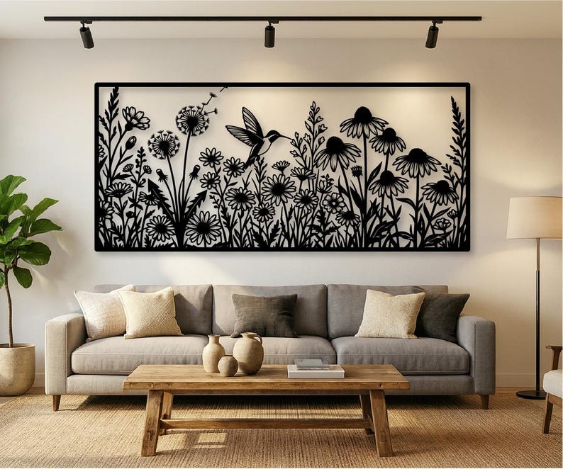 May include: A rectangular black metal wall art piece featuring a detailed silhouette of a hummingbird in flight surrounded by various wildflowers, tall grasses, and dandelion seed heads, all enclosed within a thin black rectangular frame.