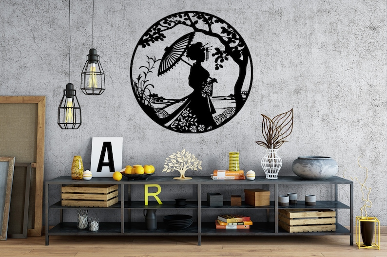 May include: Black metal wall art featuring a silhouette of a woman with an umbrella standing in a garden setting. The art is displayed on a gray wall above a black shelf with various decorative items.