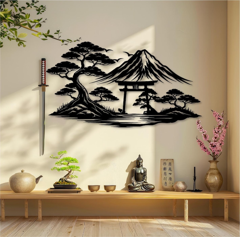 May include: A black metal wall art piece depicting a Japanese landscape with a mountain, trees, and a traditional gate. A katana hangs on the wall. A wooden bench holds a bonsai tree, teapot, bowls, a Buddha statue, and a vase with pink flowers.