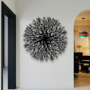 May include: A black, circular metal wall art piece resembling a tree or coral. The intricate design features numerous branches radiating from a central point. The artwork is mounted on a white wall, adding a modern touch to the interior decor.