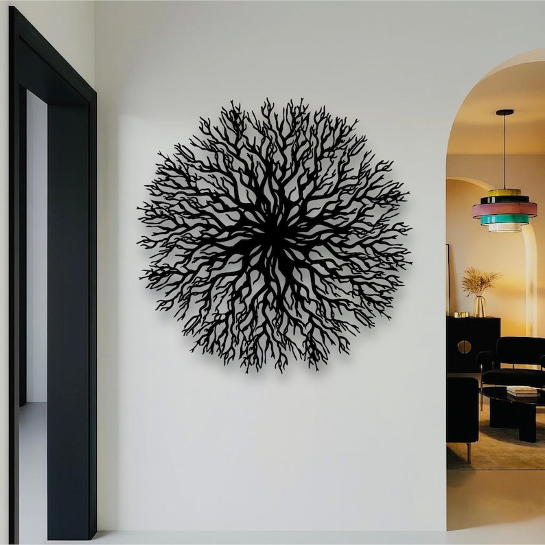 May include: A black, circular metal wall art piece resembling a tree or coral. The intricate design features numerous branches radiating from a central point. The artwork is mounted on a white wall, adding a modern touch to the interior decor.