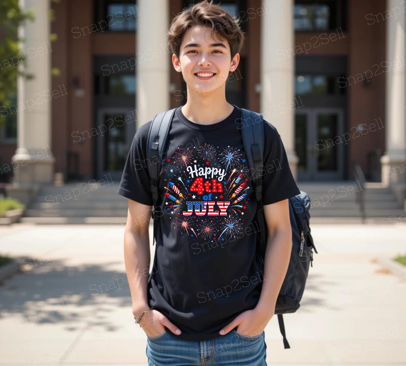 May include: A black short-sleeved t-shirt featuring a graphic print of colorful fireworks and the text Happy 4th of JULY with the word JULY styled in a red, white, and blue American flag pattern, worn with a dark backpack and blue denim jeans.