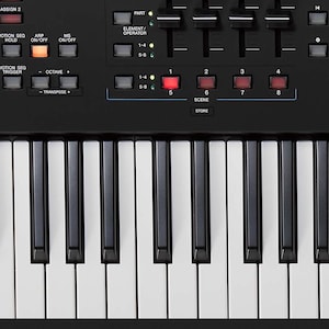 Può includere: Sintetizzatore Yamaha nero con un display digitale che mostra la parola "Creazione" e una tastiera a 61 tasti.