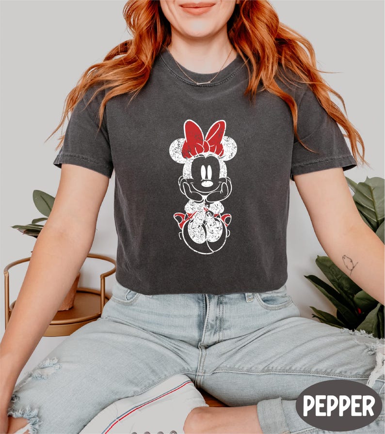 a woman with red hair wearing a mickey mouse t - shirt
