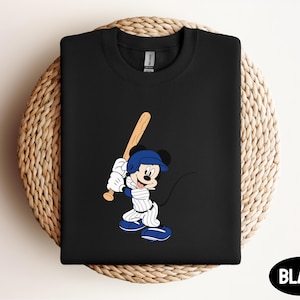a mickey mouse t - shirt with a baseball bat on it