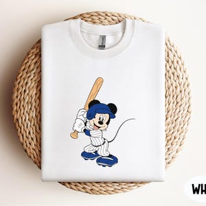 a mickey mouse t - shirt with a baseball bat on it