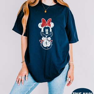 a woman wearing a mickey mouse t - shirt