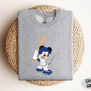 a mickey mouse t - shirt with a baseball bat on it