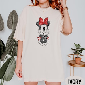 a woman with red hair wearing a mickey mouse t - shirt