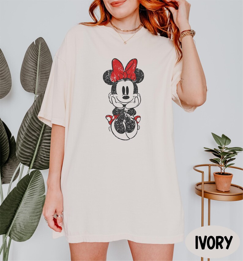 a woman with red hair wearing a mickey mouse t - shirt