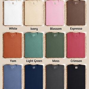 The image is a color chart displaying various comfort colors, including white, ivory, blossom, espresso, yam, light green, moss, Crimson, blue jeans, true navy, pepper, and black.