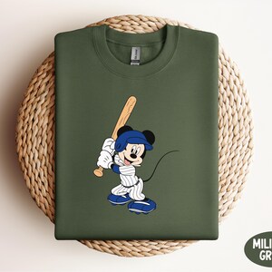 a mickey mouse t - shirt with a baseball bat on it