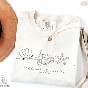 a hat, sunglasses, and t - shirt on a table