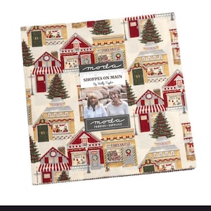 May include: A fabric square featuring a repeating pattern of quaint shops with red and white awnings, green Christmas trees, and the text "SHOPPES ON MAIN." The fabric includes the Moda Fabrics logo and the text "By Holly Taylor."