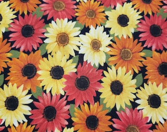 May include: A fabric pattern featuring a dense arrangement of sunflowers in various colors. The sunflowers have yellow, orange, and red petals with dark centers. Green leaves are interspersed against a black background.