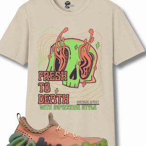 May include: A beige t-shirt with a green skull graphic and the text "Fresh to Death with Impeccable Style". A pair of orange and green sneakers with a unique, wavy sole.