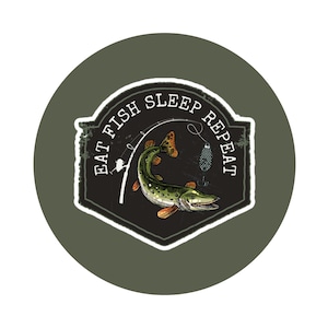 Puede incluir: Una pegatina circular con un fondo verde oscuro que presenta un emblema en blanco y negro. El emblema tiene una ilustración de un pez con el texto "EAT FISH SLEEP REPEAT". El pez es verde con aletas naranjas.