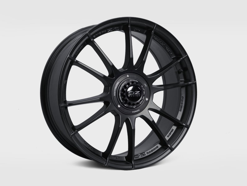 May include: Black OZ Racing forged aluminum alloy wheel with a 10-spoke design. The wheel has a black finish and a silver OZ Racing logo.