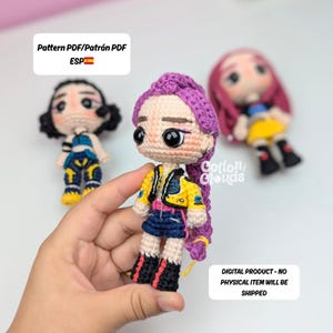 May include: Handmade crochet doll with purple hair, a yellow jacket, blue skirt, and black boots. The doll has large black eyes. The image includes text that says "Pattern PDF" and "Digital Product - No Physical Item Will Be Shipped."