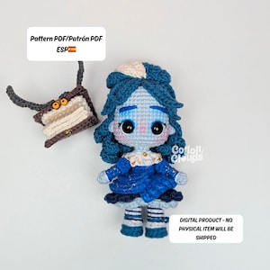 Puede incluir: Una muñeca de ganchillo con cabello azul y un vestido azul, junto con un accesorio a juego. La muñeca tiene grandes ojos negros y una tez pálida. La imagen incluye el texto "Pattern PDF/Patrón PDF ESP" y "DIGITAL PRODUCT - NO PHYSICAL ITEM WILL BE SHIPPED."