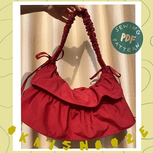 May include: A red ruffled handbag with a gathered top and a single strap. The bag has a gathered, ruffled design and a simple, casual style. The text "Sewing PDF Pattern" is visible in the image.