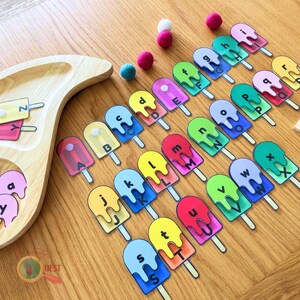 May include: A set of colourful popsicle-shaped cards with the letters of the alphabet printed on them. The cards are arranged in alphabetical order and are perfect for learning the alphabet.