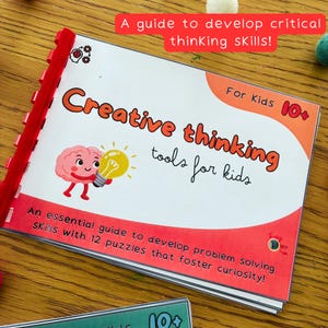 May include: A children's book titled "Creative Thinking Tools for Kids" with a red spine. The cover features a cartoon brain holding a lightbulb and the text "For Kids 10+". The book is a guide to develop critical thinking skills.