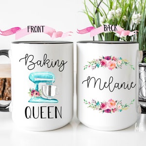 May include: White ceramic mug with a black rim and handle. The front of the mug has a blue and silver stand mixer with pink flowers and the text "Baking Queen". The back of the mug has a floral wreath with the name "Melanie".