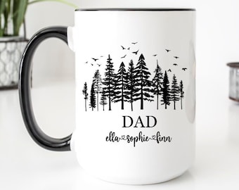 May include: White ceramic mug with a black handle. The mug has a black silhouette of a forest with birds flying above. The text "DAD" is printed below the forest, and the text "ella♡sophie♡finn" is printed below that.