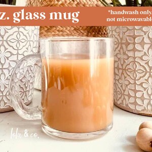 May include: A clear glass mug filled with a light brown beverage. The mug has a handle and is sitting on a white surface. The text "11oz. glass mug" is in the top left corner of the image. The text "*handwash only, not microwavable" is in the top right corner of the image. The text "lola & co." is in the bottom left corner of the image.