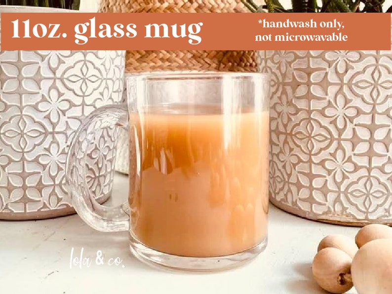 May include: A clear glass mug filled with a light brown beverage. The mug has a handle and is sitting on a white surface. The text "11oz. glass mug" is in the top left corner of the image. The text "*handwash only, not microwavable" is in the top right corner of the image. The text "lola & co." is in the bottom left corner of the image.