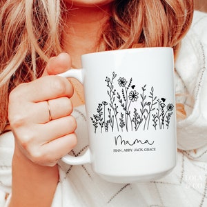 May include: White ceramic mug with a black floral design and the word "Mama" with the names Finn, Abby, Jack, Grace underneath.