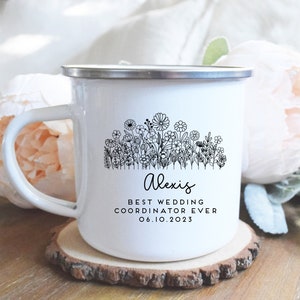 Może przedstawiać: Biały kubek emaliowany z czarnym wzorem kwiatowym i tekstem "Alexis Best Wedding Coordinator Ever 06.10.2023".