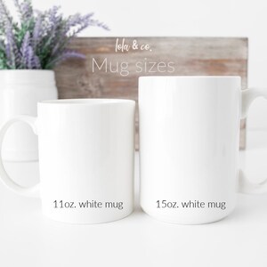 Pu&ograve; includere: Due tazze in ceramica bianca, una da 11 oz e l'altra da 15 oz, su una superficie bianca. Il testo "Lola & Co. Mug sizes" &egrave; visibile su un cartello di legno dietro le tazze.