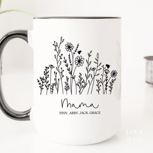 May include: White ceramic mug with a black rim and handle. The mug features a black and white illustration of flowers and the word "Mama" with the names Finn, Abby, Jack, Grace underneath.