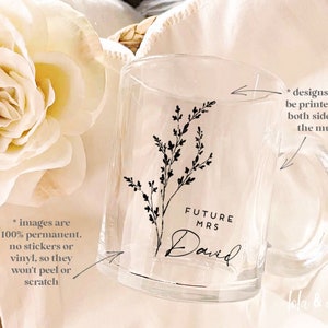 K&ouml;nnte beinhalten: Klare Glas-Tasse mit einem schwarzen Blumenmuster und dem Text "FUTURE MRS David". Die Tasse hat einen Henkel und das Design ist auf beiden Seiten bedruckt.