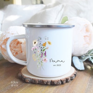 May include: White enamel mug with a floral design and the text "Mama est. 2023".