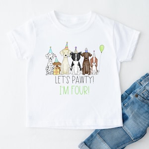 Op de afbeelding: Wit T-shirt met een afbeelding van vijf honden die feestmutsen dragen en een cadeau vasthouden. De tekst "Let's Pawty! I'm Four!" staat onder de honden.