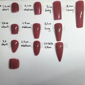Op de afbeelding: Een grafiek met verschillende nagelvormen en -maten in rood. De vormen omvatten vierkant, kist, amandel, stiletto en teennagels. De maten worden in centimeters gemeten en vari&euml;ren van 1,6 cm tot 4,5 cm.