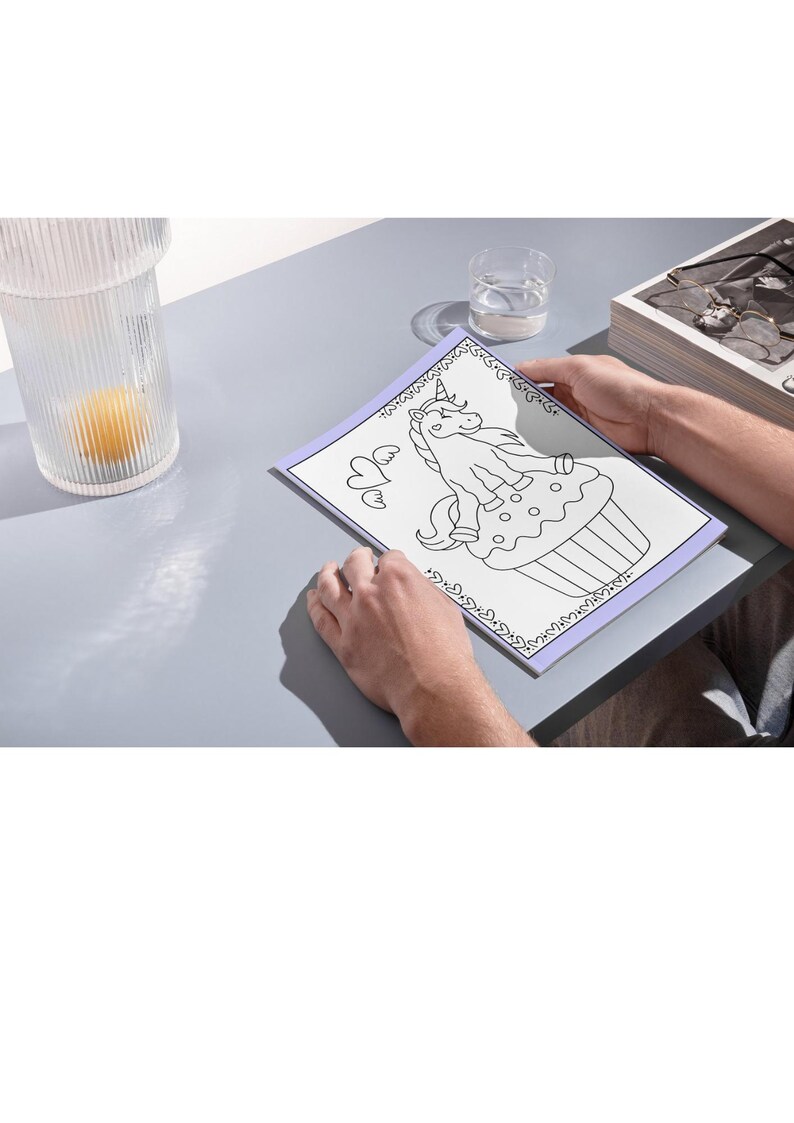 May include: A black and white coloring page featuring a unicorn sitting on a cupcake. The unicorn has a horn, mane, and tail. The cupcake has sprinkles and a cherry on top. The page is surrounded by a decorative border.