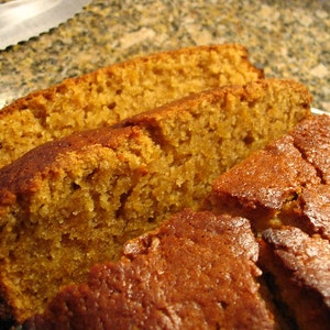 May include: Close-up of sliced, golden-brown bread. The bread has a textured surface and appears moist. The slices are arranged on a plate, showcasing the baked goods' interior texture and color.