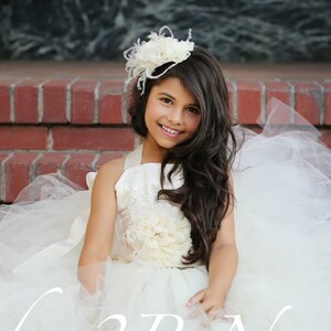 Ivory tulle flower girl dress.  Two piece dress with tutu skirt.  Skirt is hand knotted on satin ribbon.  Top is corset style with open back and lace overlay.