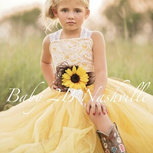 Wedding flower girl dress in yellow sunflower tulle with lace overlay bodice.