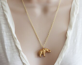 May include: A gold chain necklace with a gold elephant pendant.