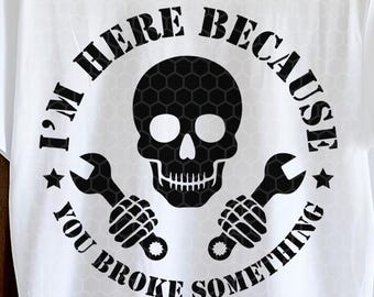 May include: White t-shirt with a black graphic featuring a skull, wrenches, and the text "I'M HERE BECAUSE YOU BROKE SOMETHING." The design is circular, with stars and a honeycomb pattern on the skull. A straw hat hangs above the shirt.