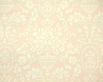 May include: Wallpaper featuring a repeating pattern of cream-colored floral arrangements in urns and scrolling acanthus leaves set against a soft, pale peach background. The design includes symmetrical botanical motifs and octagonal frames.