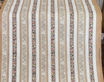 May include: A roll of vintage wallpaper with a repeating vertical stripe pattern. The design features alternating stripes of white, tan, and floral patterns in pink, brown, and gray. The edge of the roll has text that reads "UNGROUNDED II" and "TOP".