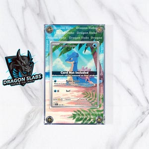 May include: A clear acrylic case displaying a Lapras Pokémon card. The card features a blue and white Lapras illustration with text in English and Spanish. The case has the text "Dragon Slabs" repeated on the border.